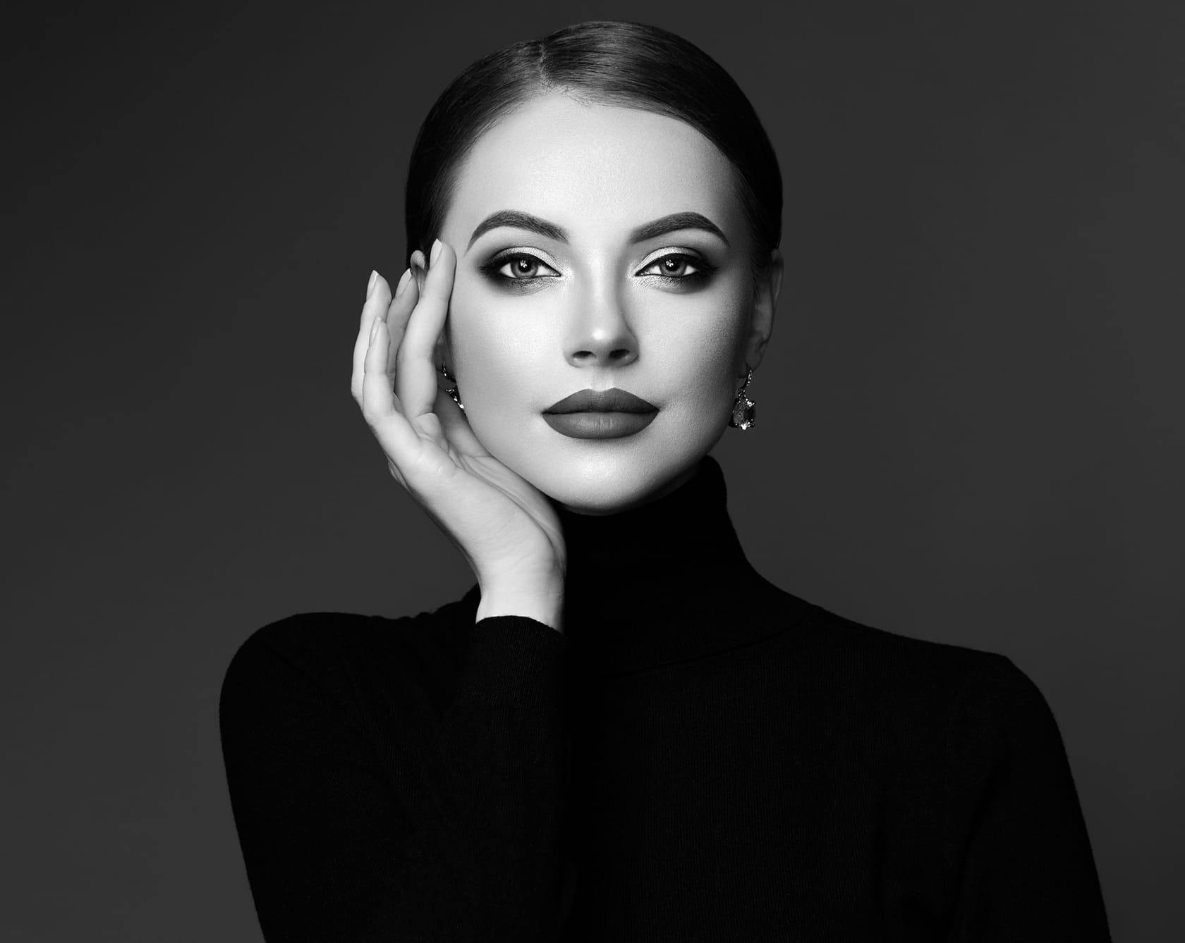 a black and white image of a woman in a black turtleneck