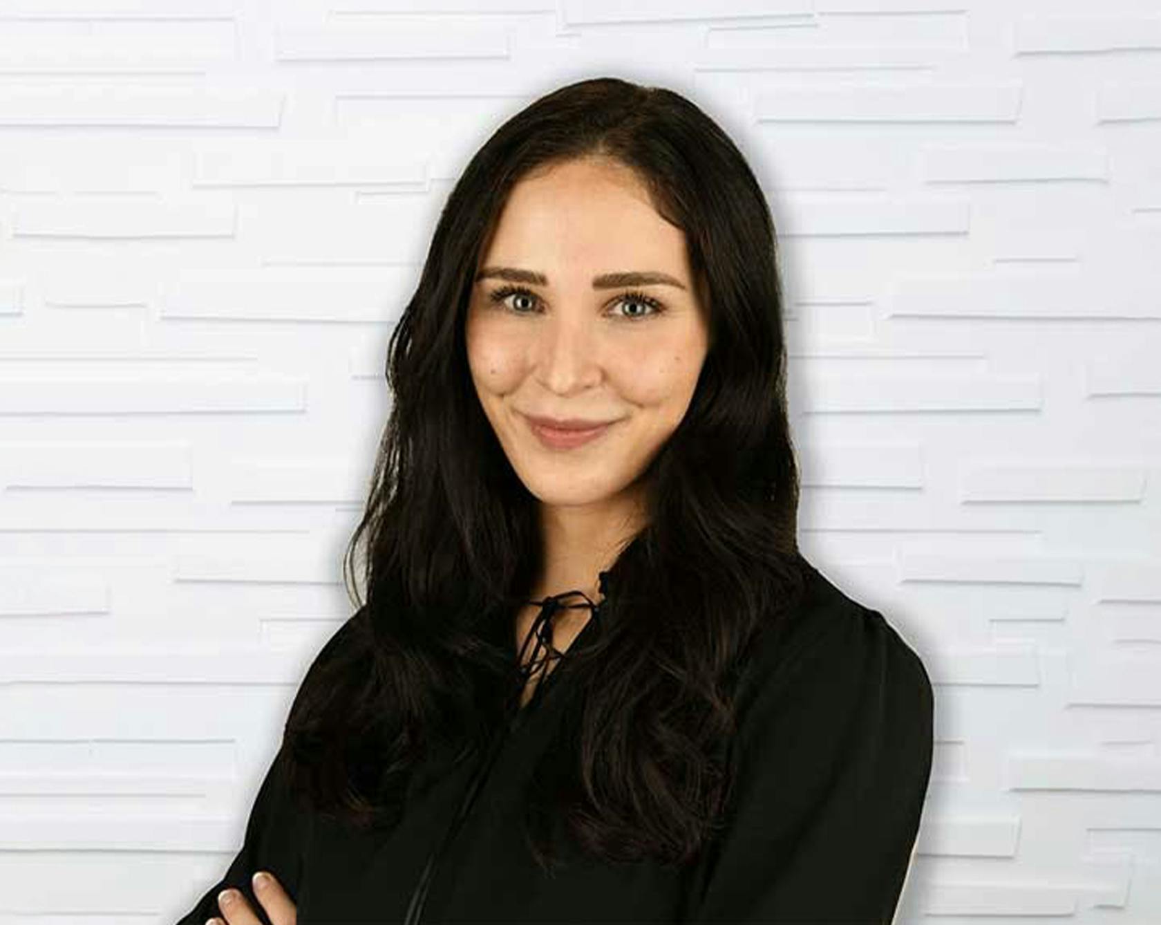 woman with dark hair smiling in black top