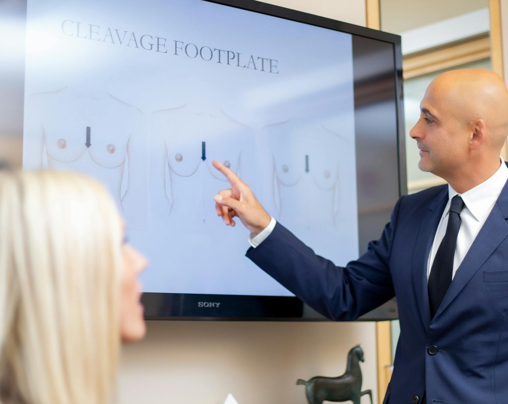 an image of Dr. Egrari talking to a patient about breast augmentation