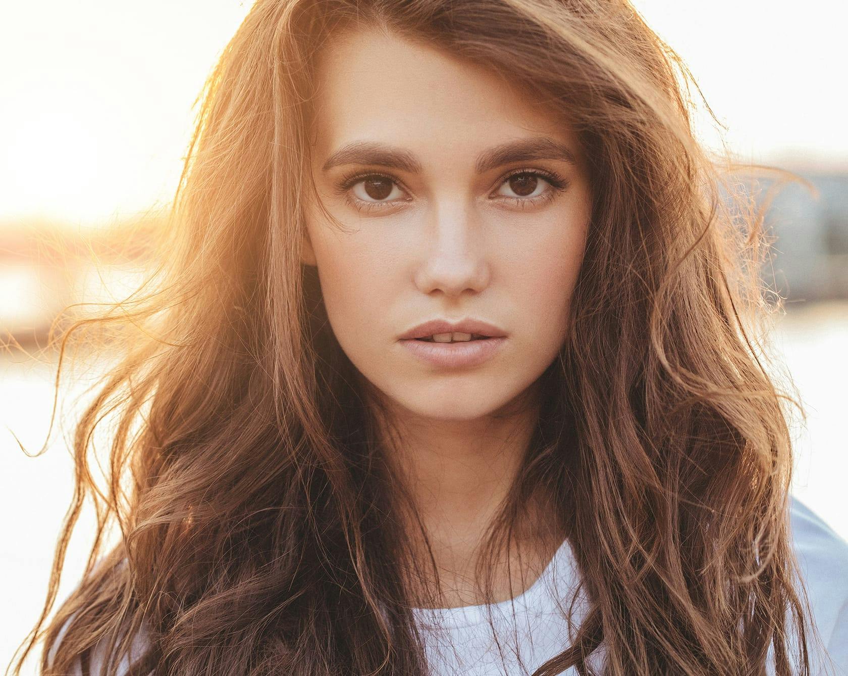 a brunette woman with brown eyes in a white shirt