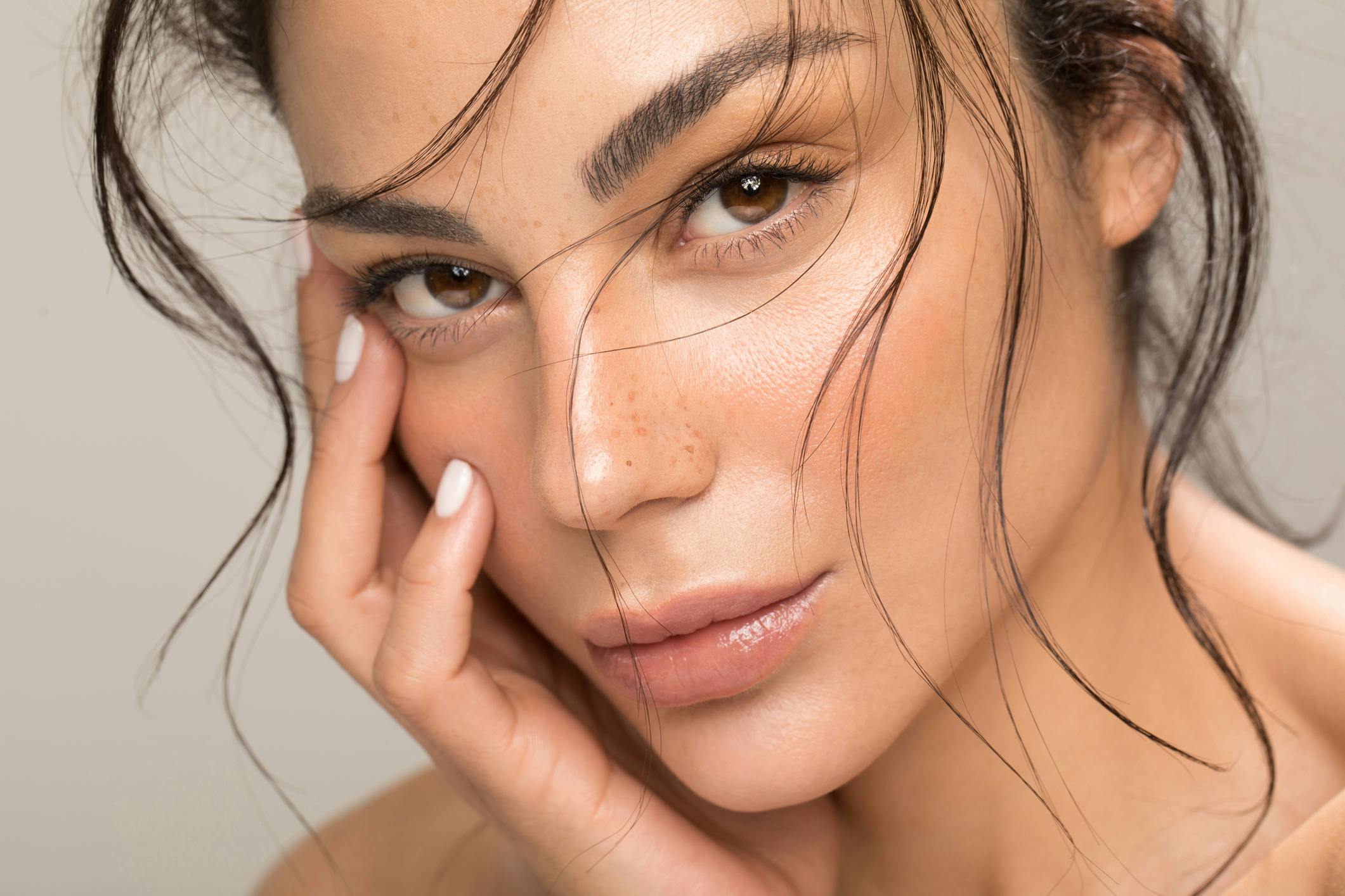 an image of a close up of a brunette woman with her hand on her face