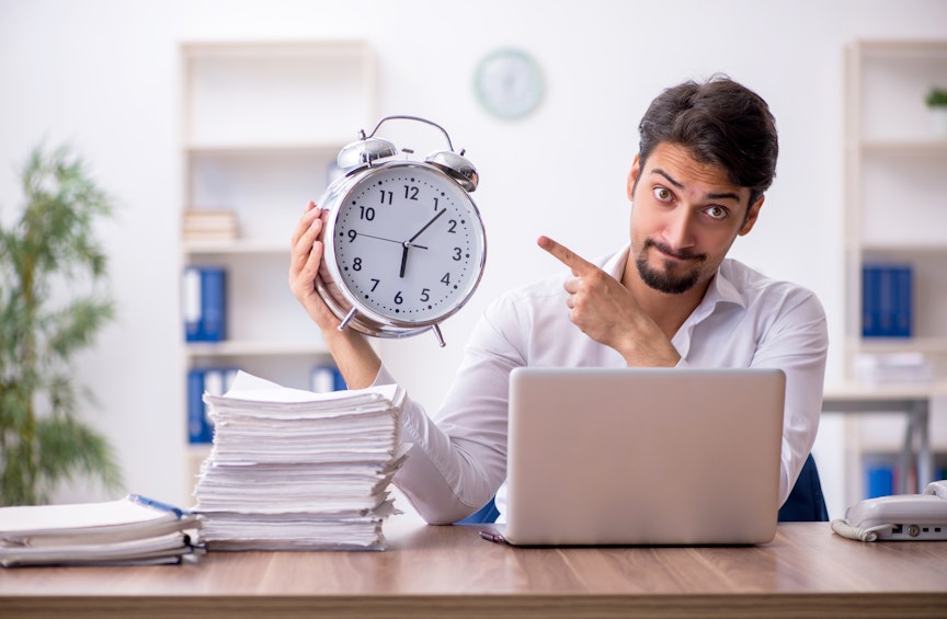 Mann hält eine Uhr in der Hand und zeigt darauf