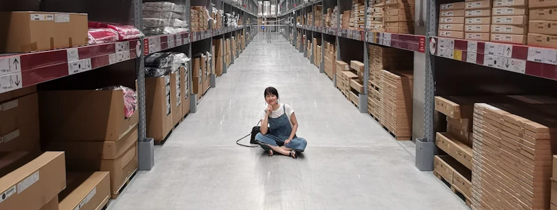 Smiling woman sitting in the middle of a warehouse