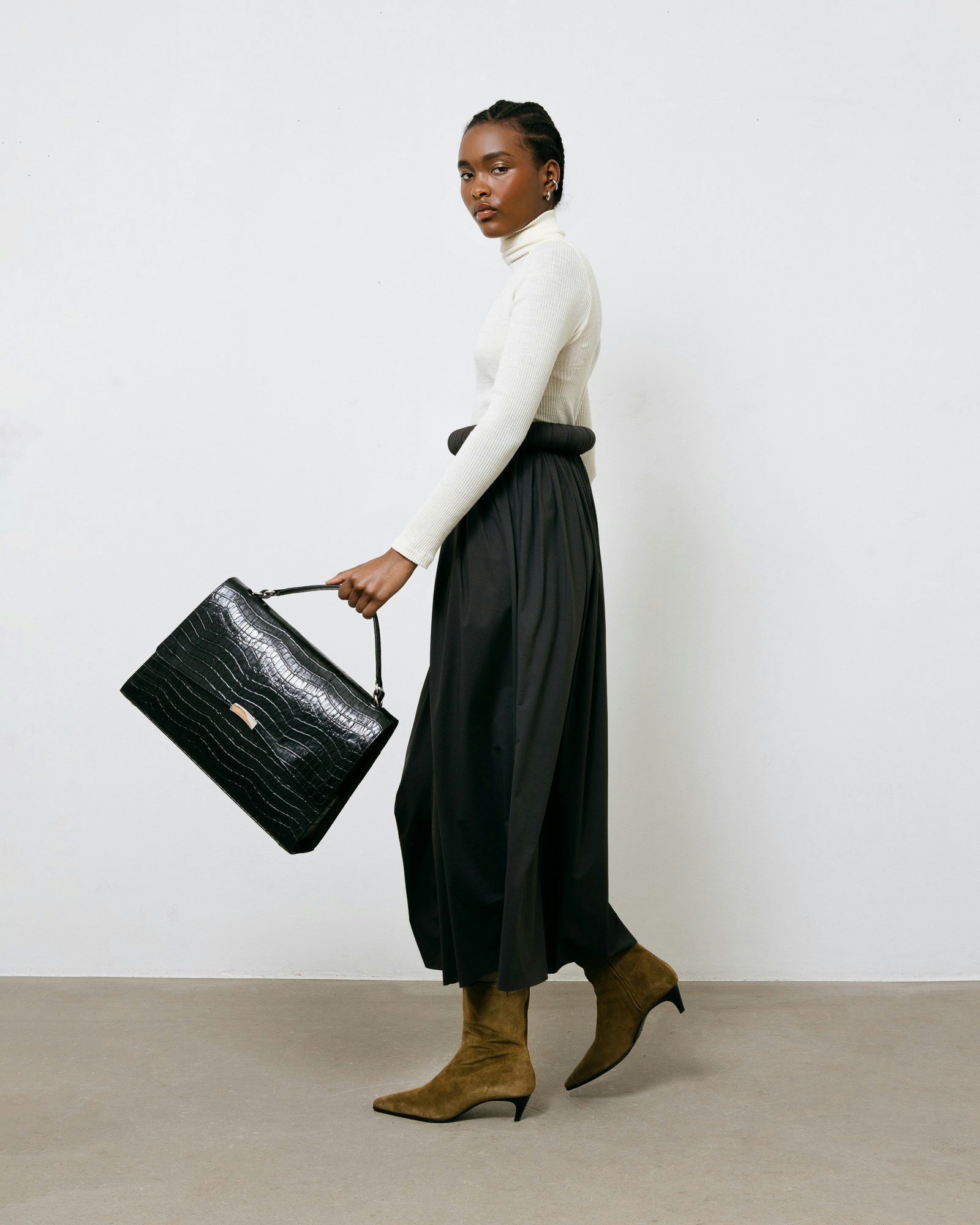 woman holding a black croco BY BANOO bag