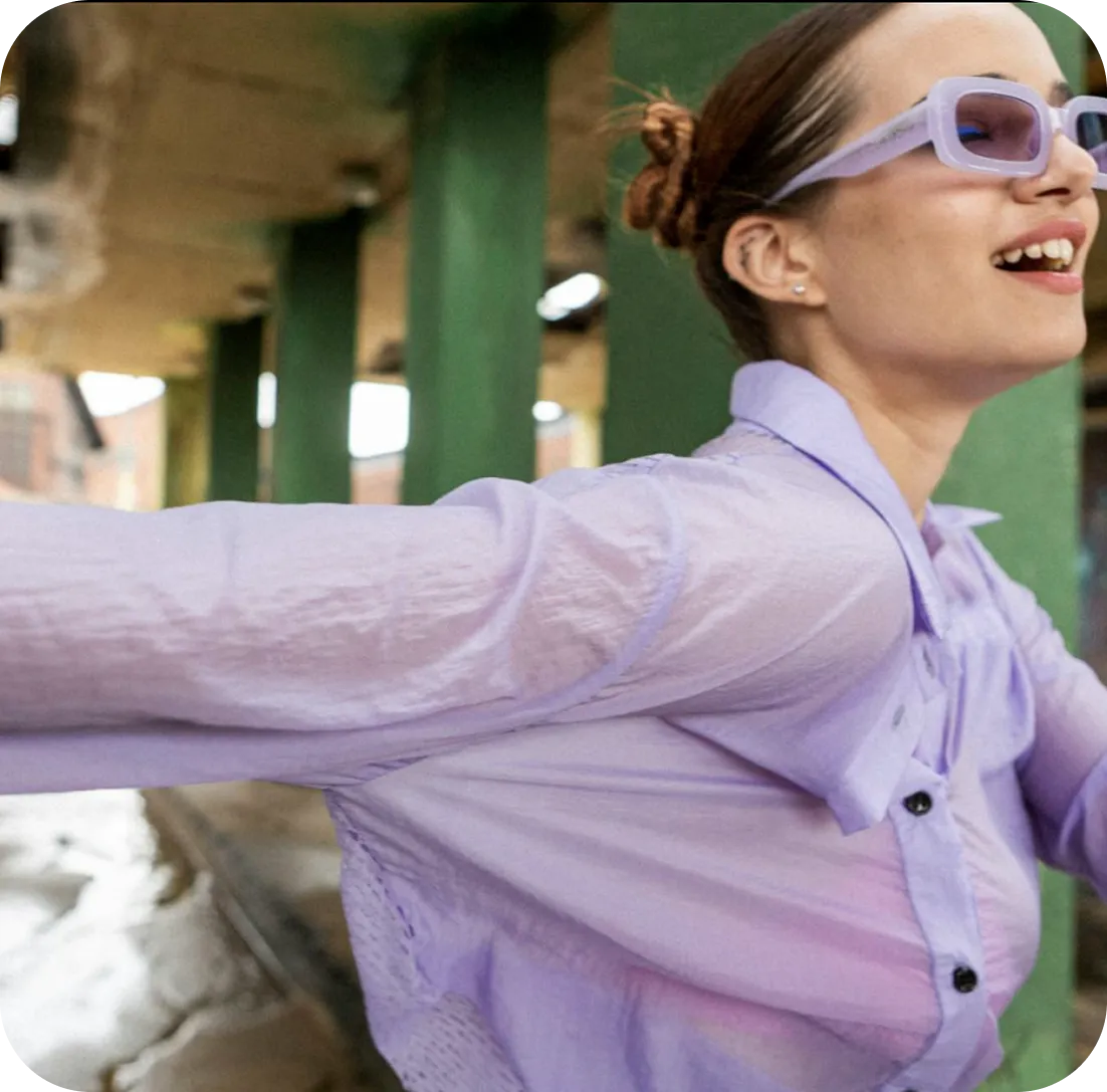 en kvinde, med lilla skjorte og sun glasses