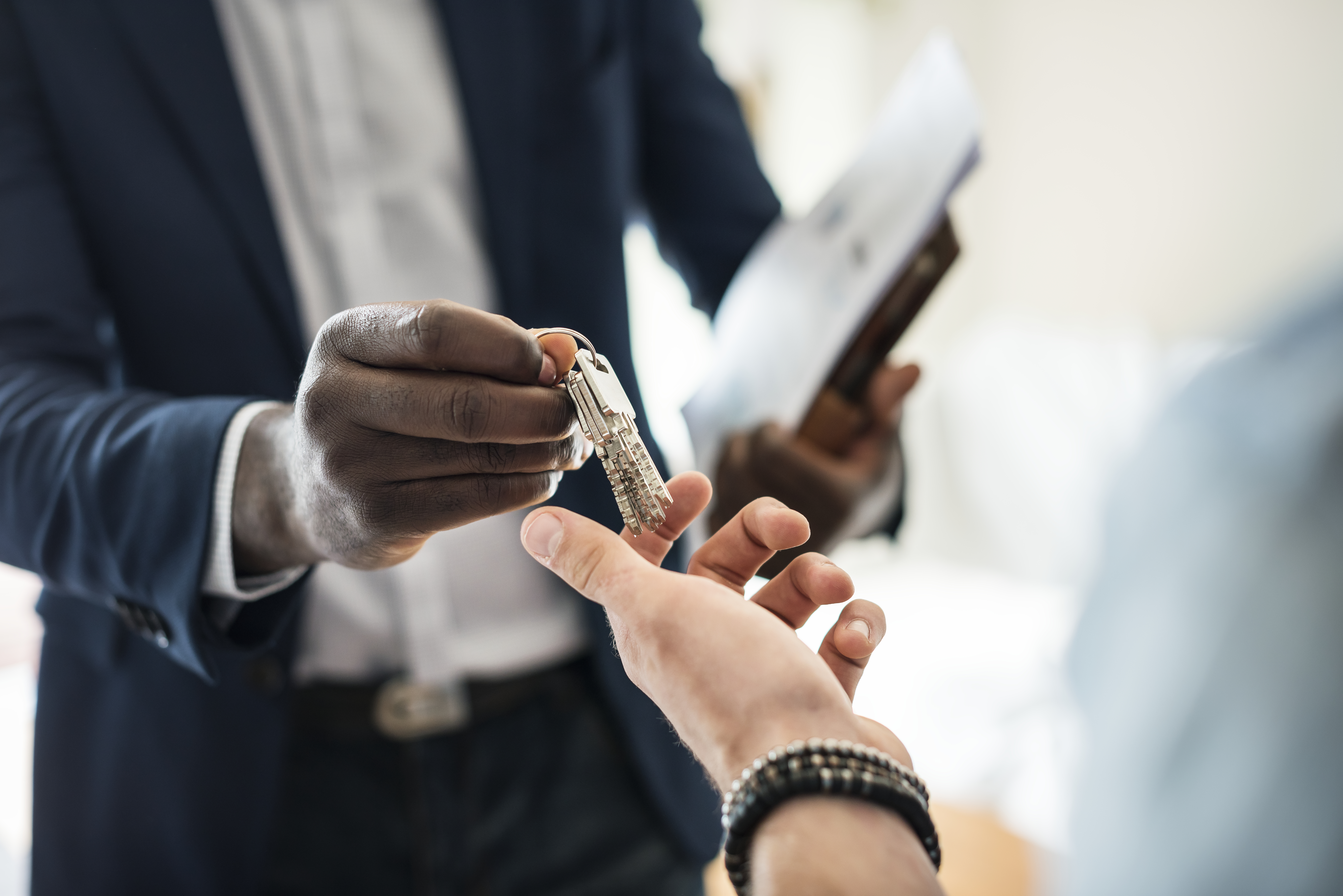 A ring of keys being handed over from one person to another