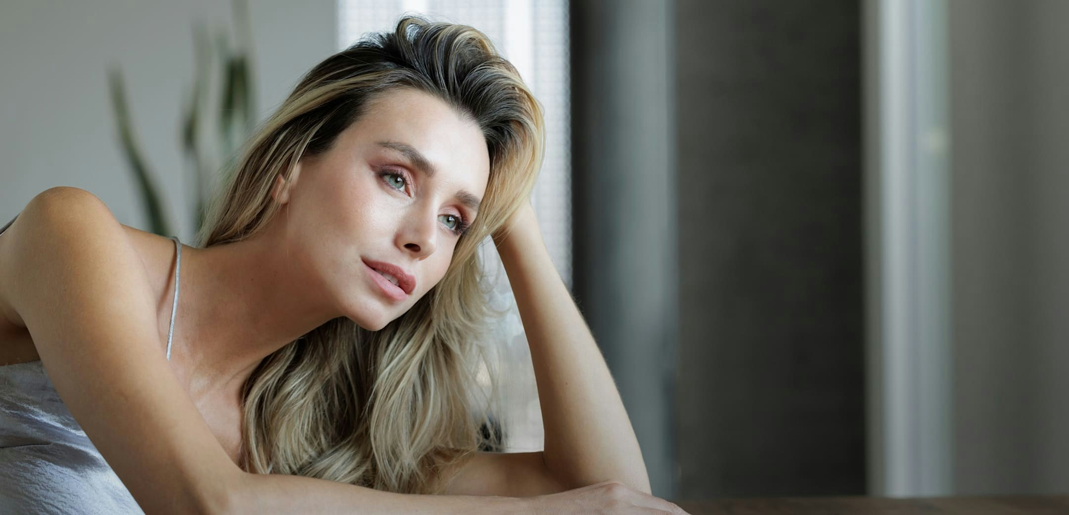 Woman with blonde hair propping her head on her hand