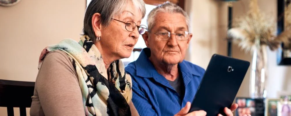 Two senior citizens looking at tablet