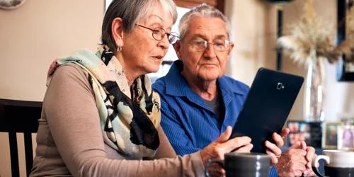 Two senior citizens looking at tablet