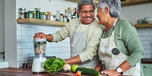 Older couple making smoothie with foods that lower blood pressure