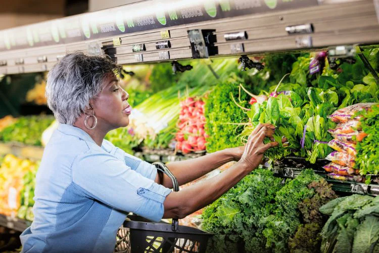 older adult woman shopping for healthy produce at grocery store