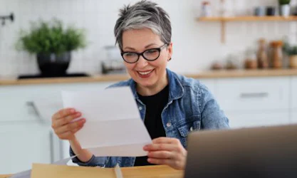 older woman looking at piece of paper and smiling
