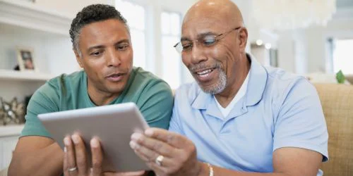 two older men looking at tablet