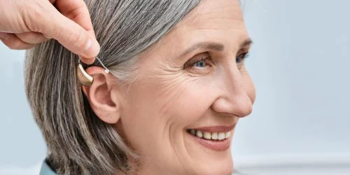 older woman on Medicare getting hearing aid fitted