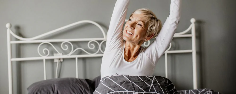 older woman waking up from a good night of sleep