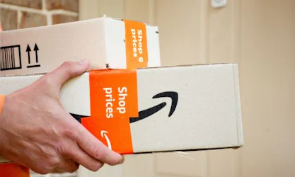 Person holding Amazon boxes