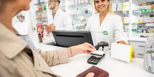 Woman using OTC card at pharmacy