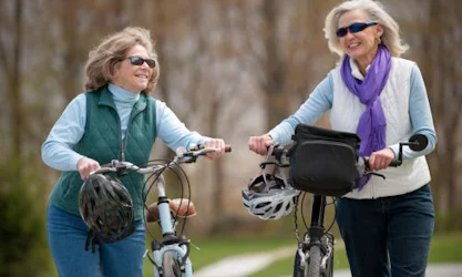 Senior women walking bikes outside