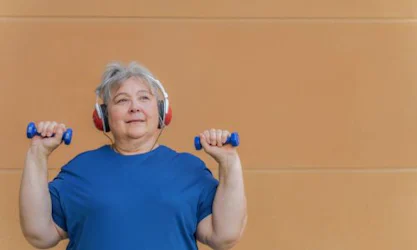 Older woman with weights and headphones working out