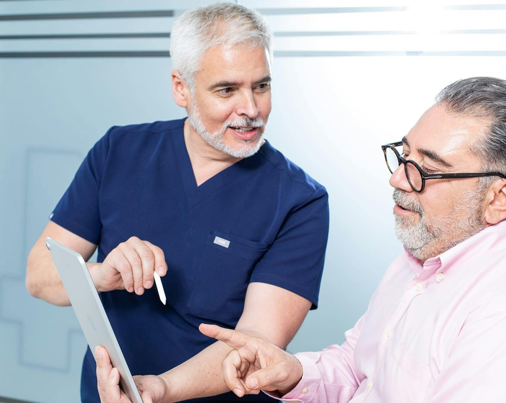 Doctor Explaining Something on a Clipboard to Patient