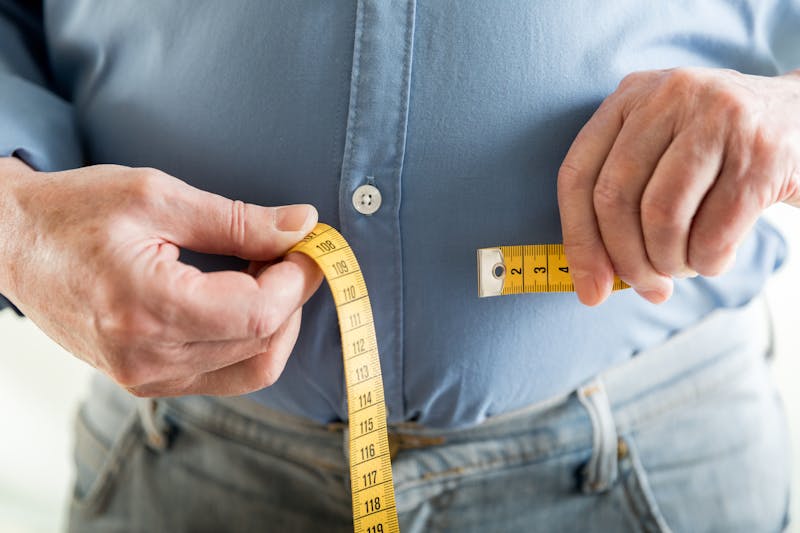 Man measuring his stomach area