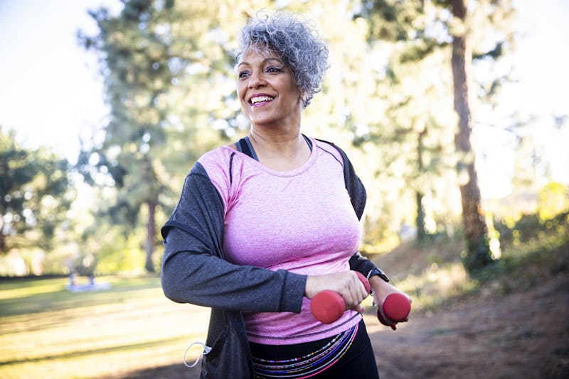 Woman walking outside while carrying hand weights