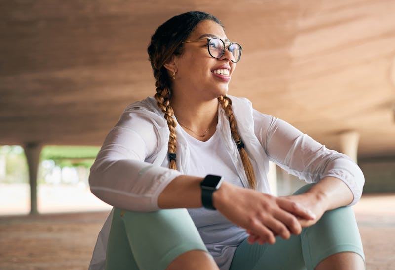 Woman sitting on the ground wearing workout gear