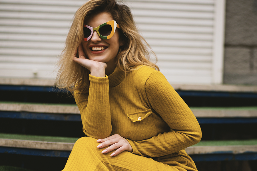 moça sorrindo de vestido amarelo