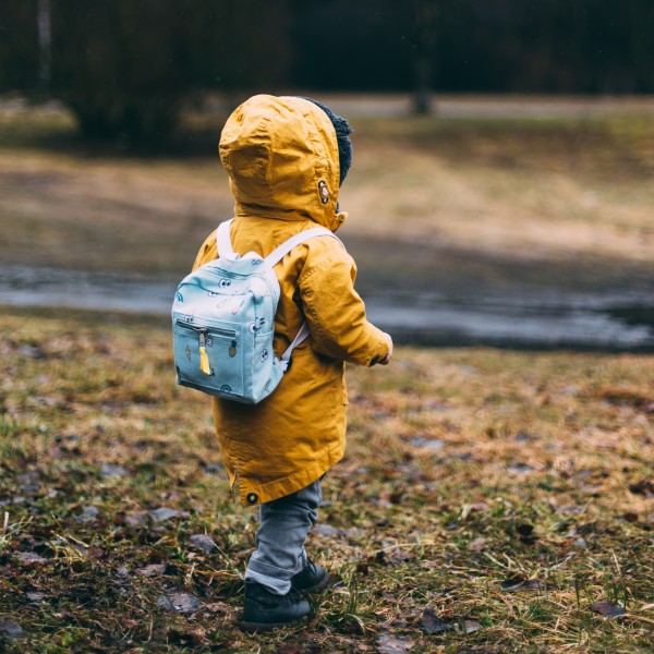 menino vestido capa de chuva e mochila