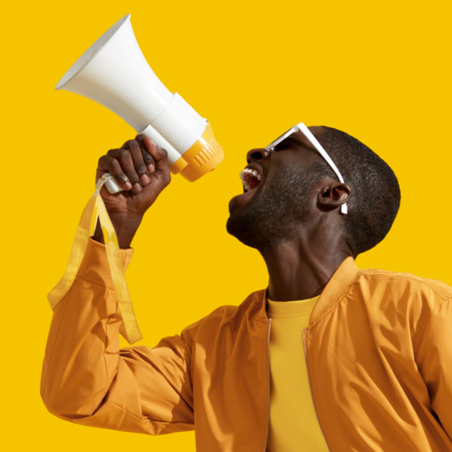 um homem de óculos gritando feliz em um megafone