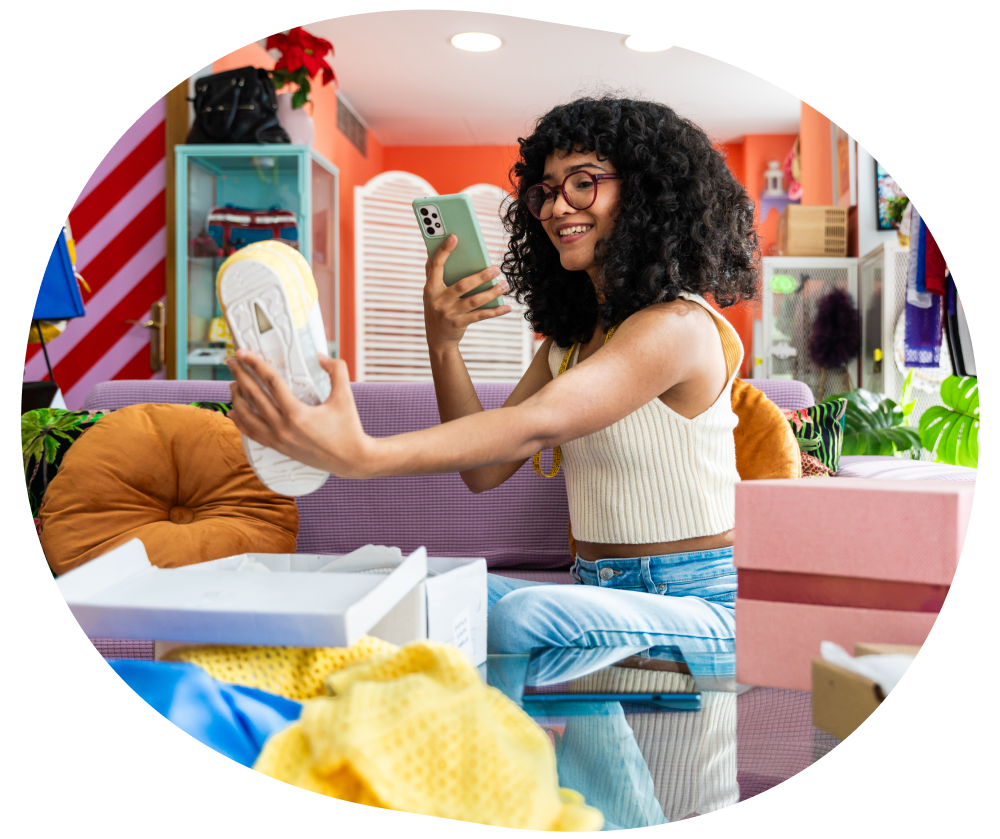 imagem destaca mulher sorrindo tirando foto de um produto