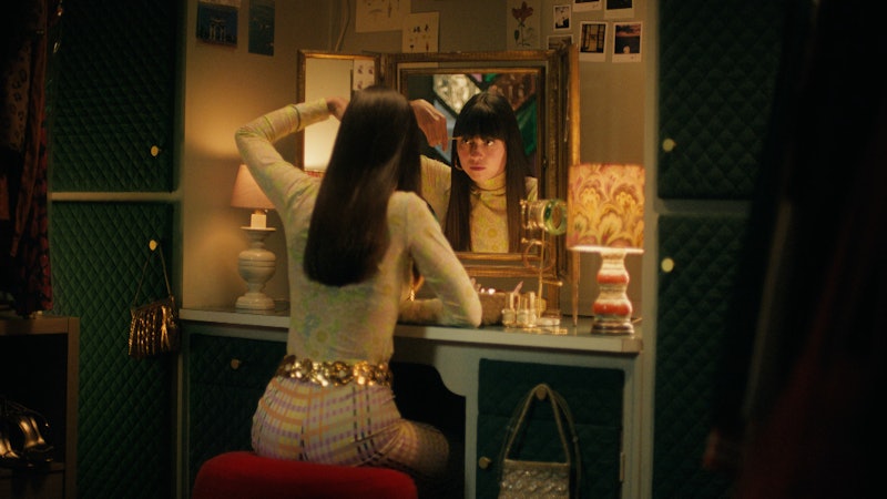 New investor Gigi Auburn is sat in front of a gold-framed mirror trimming her fringe.