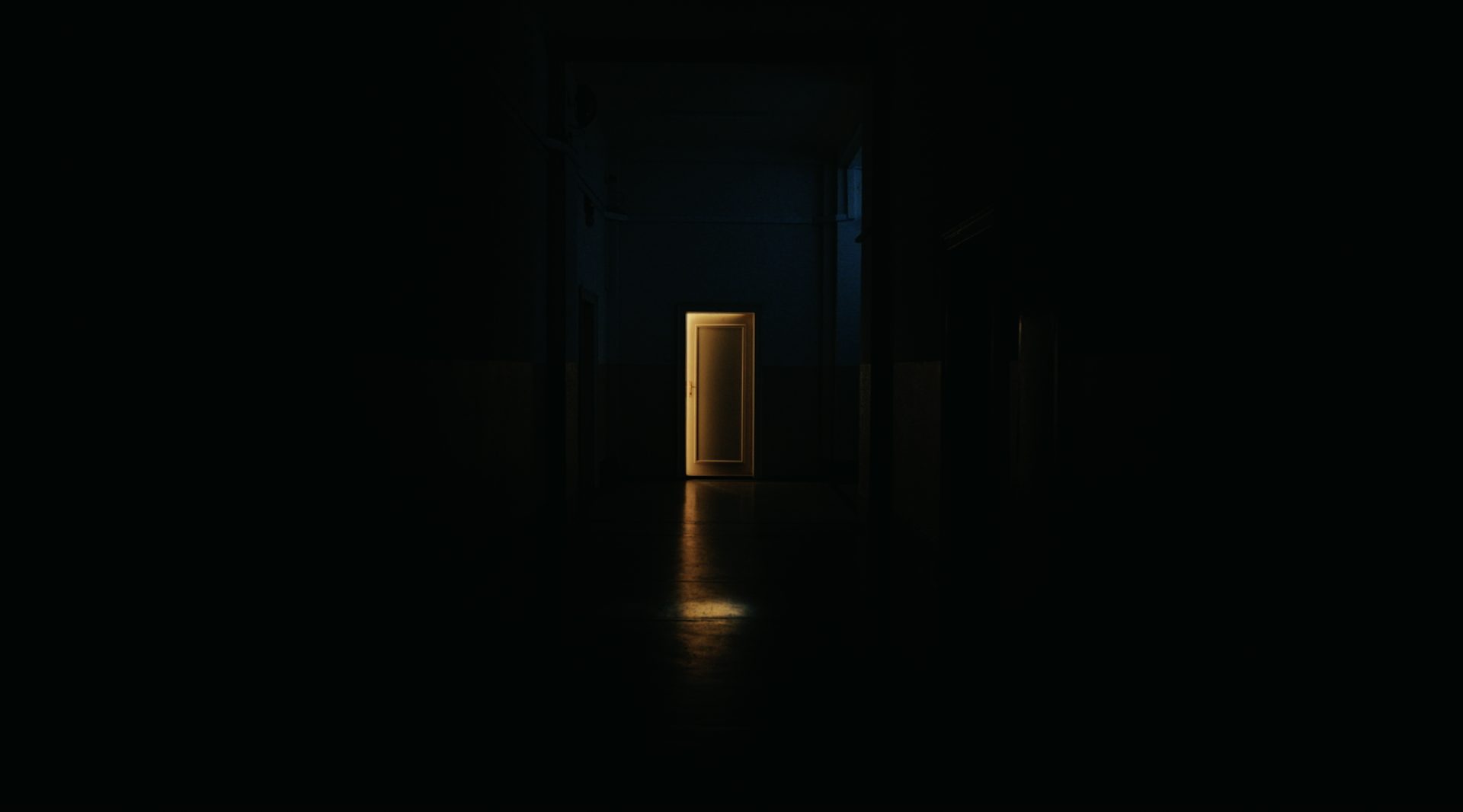A door in a dark room is slightly ajar so that the golden light from the next room pours in—symbolising confidence in gold.