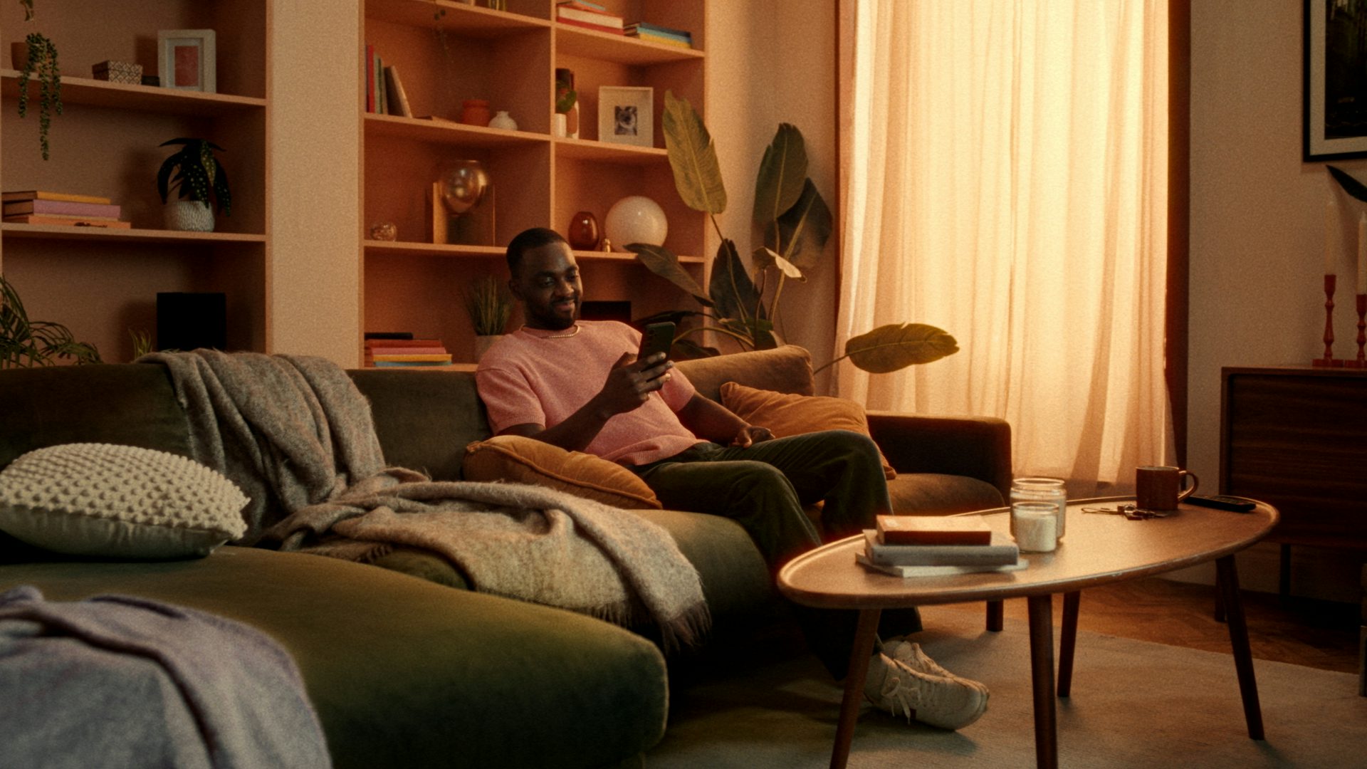 Man sitting on a couch with his phone looking pleased