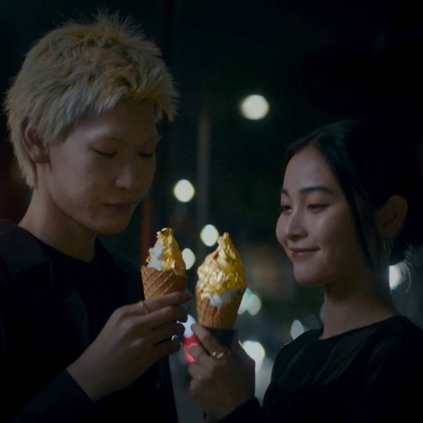 Two people smiling at the icecream cones in their hands