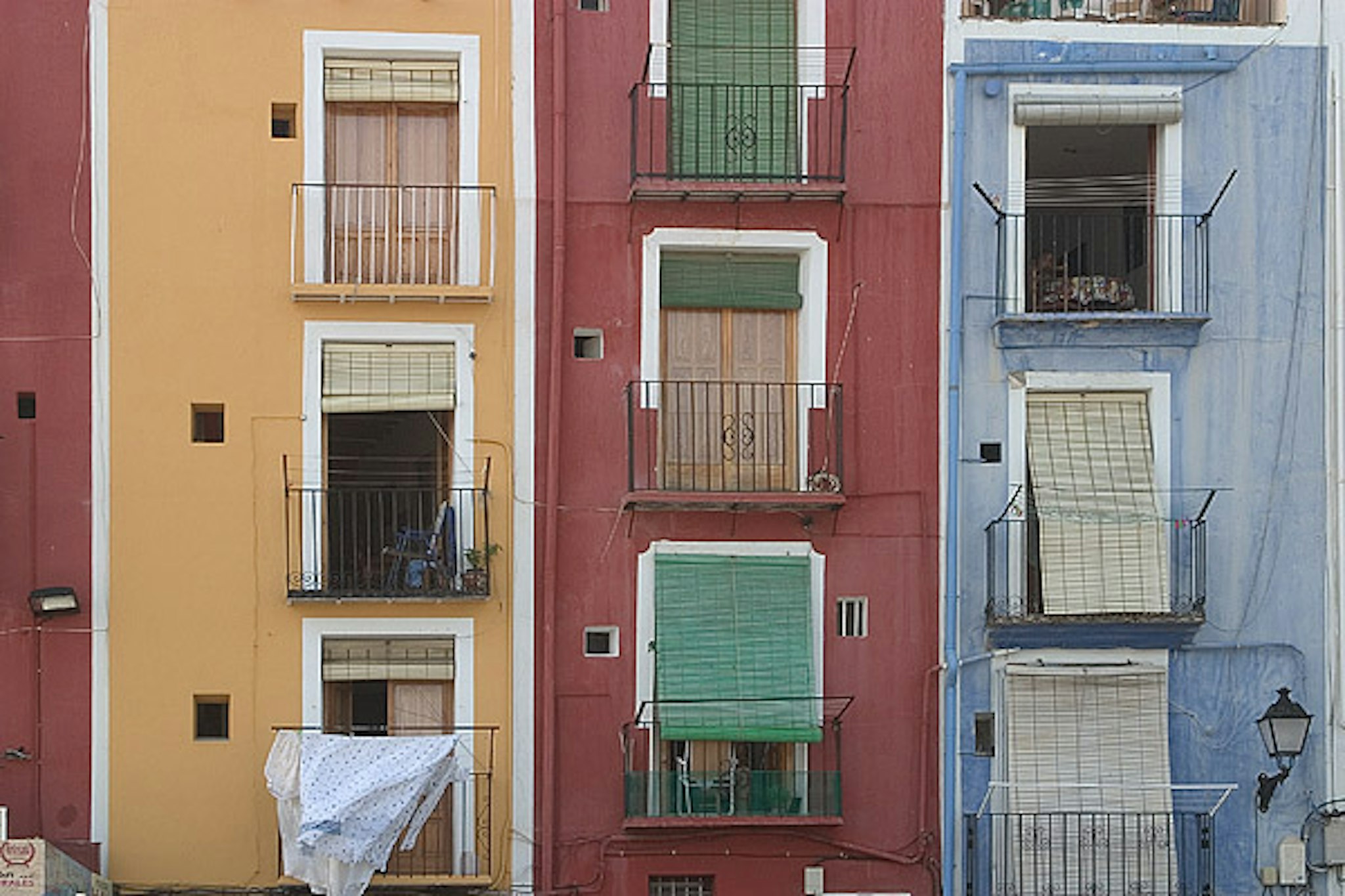 Colorful Spanish-style apartment building with balconies facing the street.