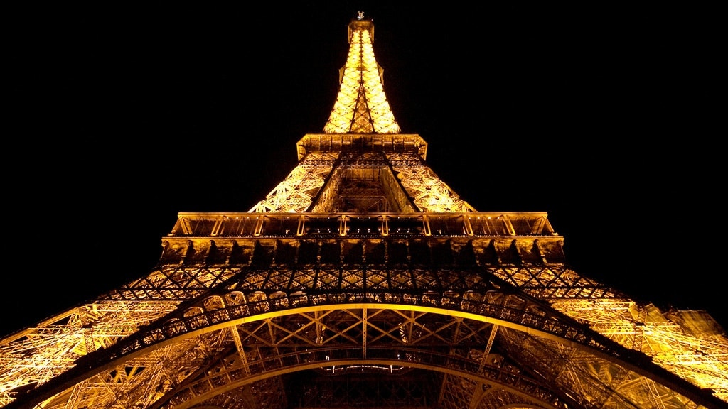 A lit-up Eiffel Tower at night against a dark sky with the words "love Paris" visible on the tower.