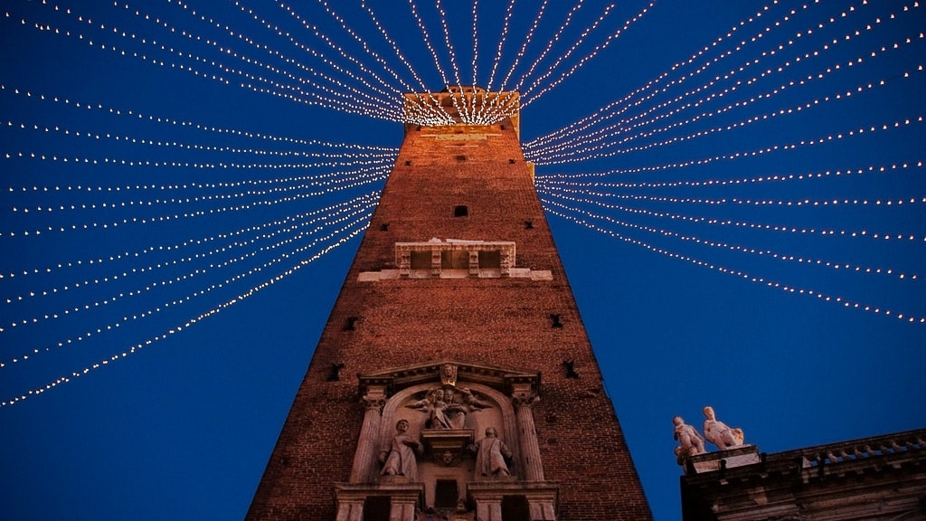 A tall tower at night, illuminated with lights and adorned with festive decorations.