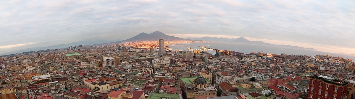 Una vista a 360 dei quartieri con edifici, linea di volo e montagna lontana.