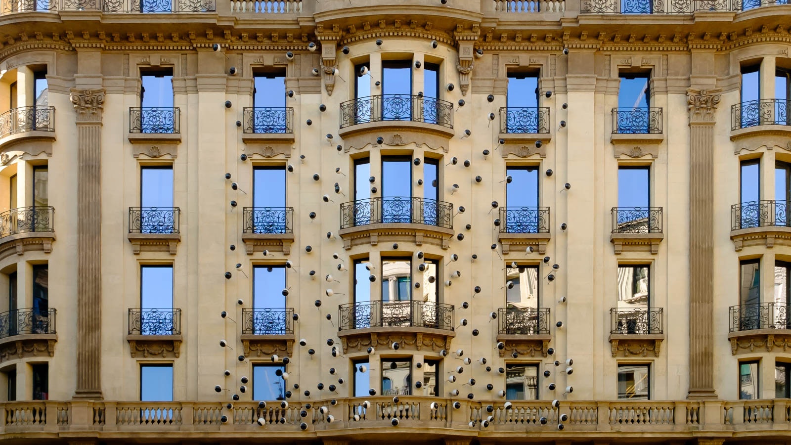 Edificio con numerosi finestre e balconi, dotati di elementi decorativi e luce intorno a loro.