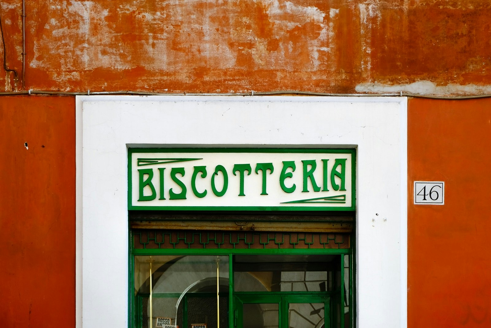 Pizzeria con esterno arancione e segno verde.