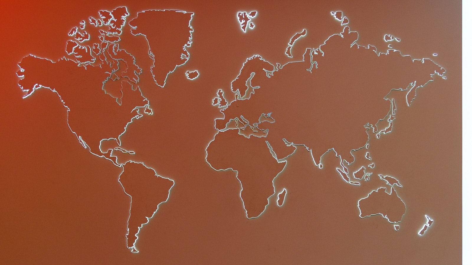 A world map with country outlines made out of thin, white lines on a brown background.