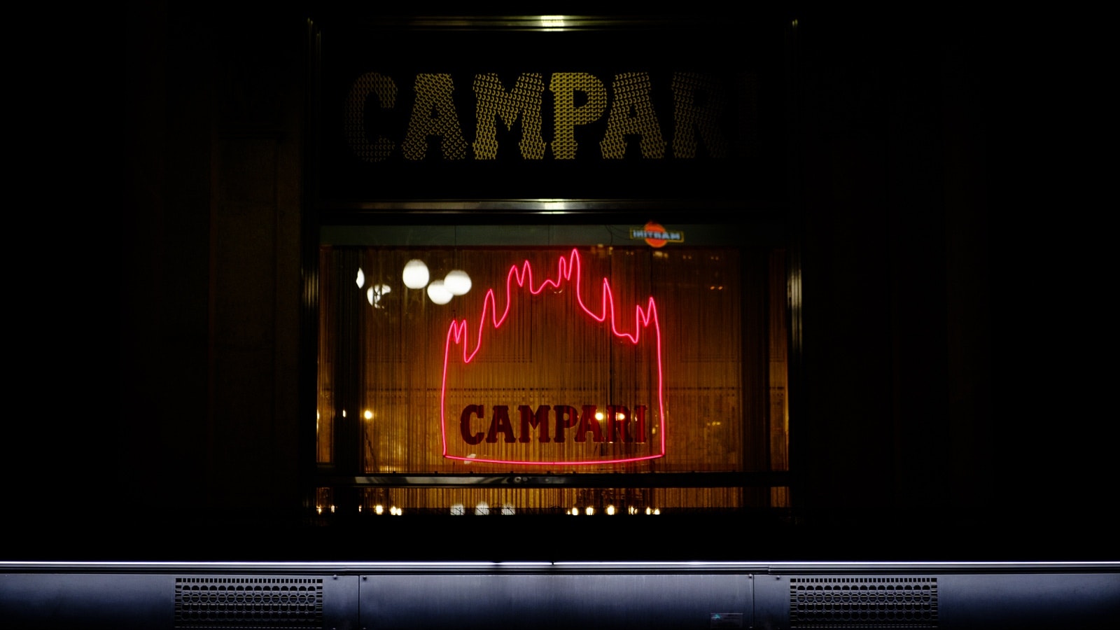 Neon sign for a restaurant in an urban setting at night.