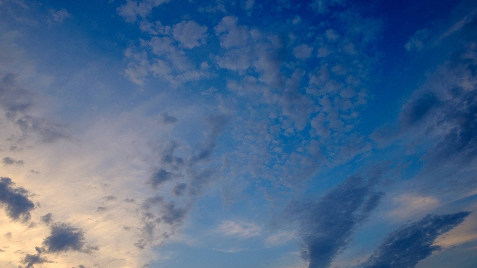 Nuvole scure con lievante sfumature di tramonti, sfondo in tinta di blu.