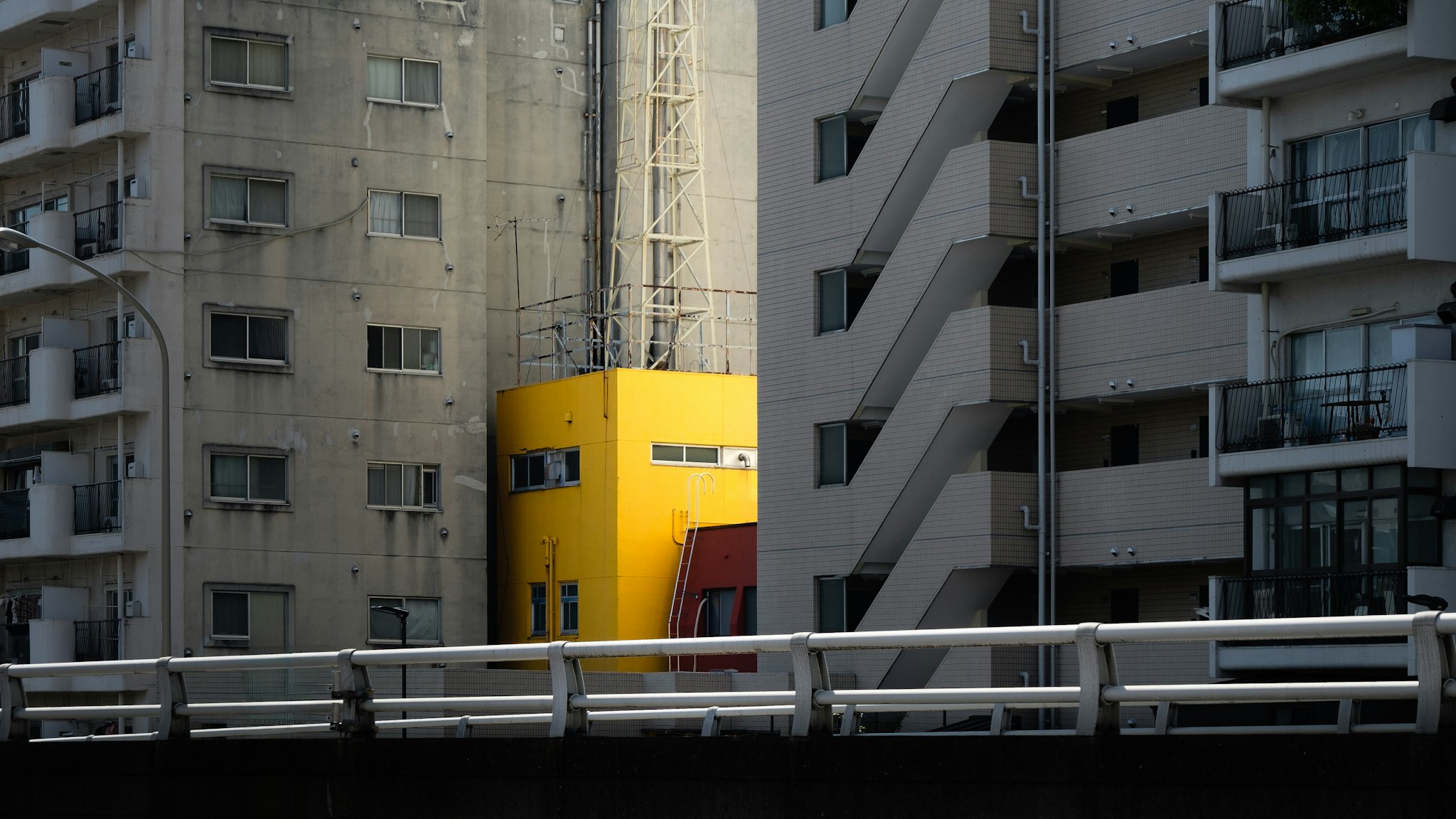 Building with bright yellow entrance door. A red fire hydrant is in front of it.