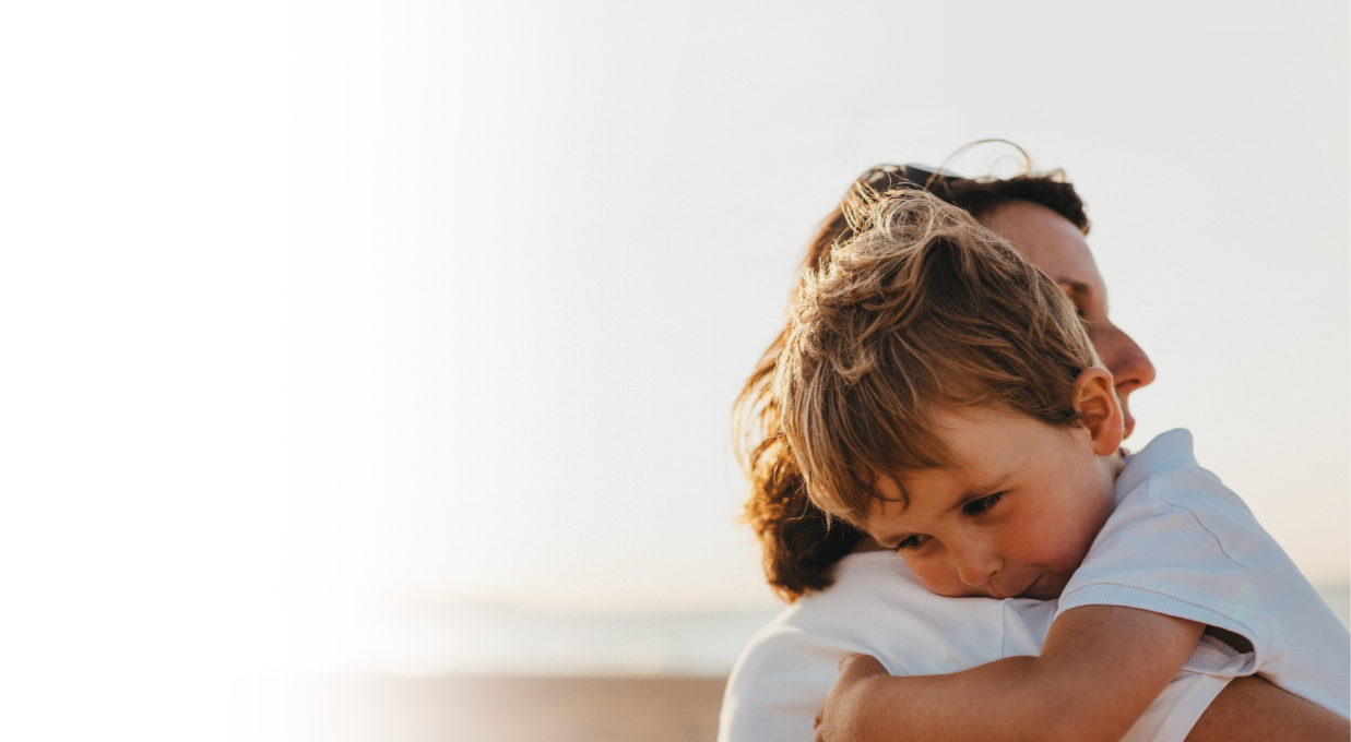 Woman holding child at the beach