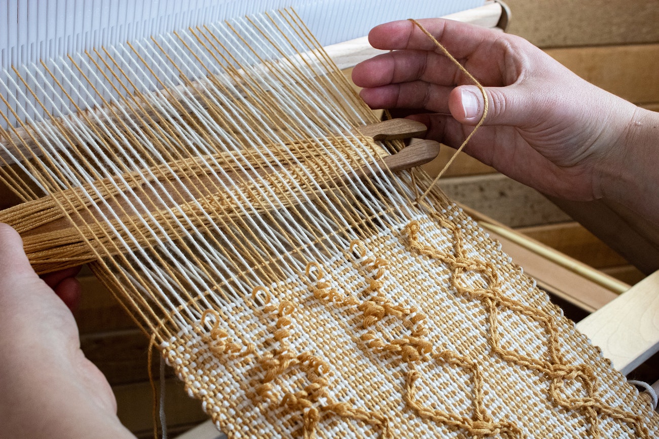 Jessica demonstrating a step in the catenpile weaving process. Photo by Jessica Lambert