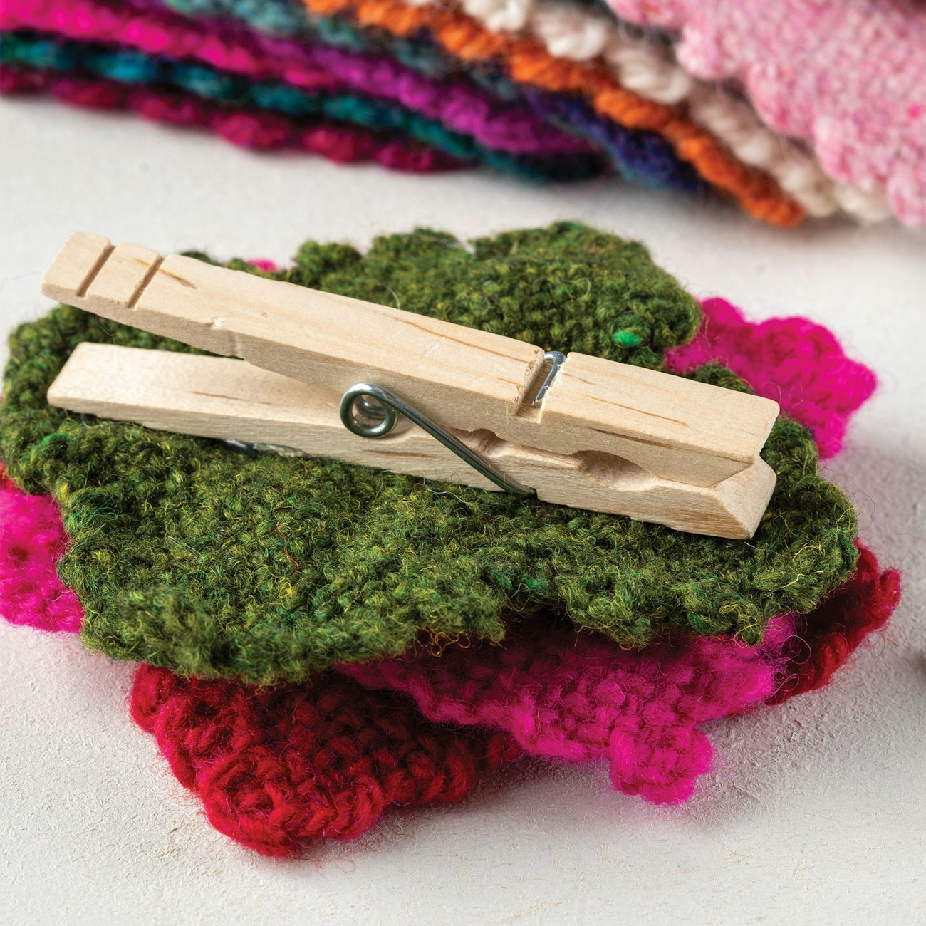 The assembled flower with leaves glued to a clothespin.