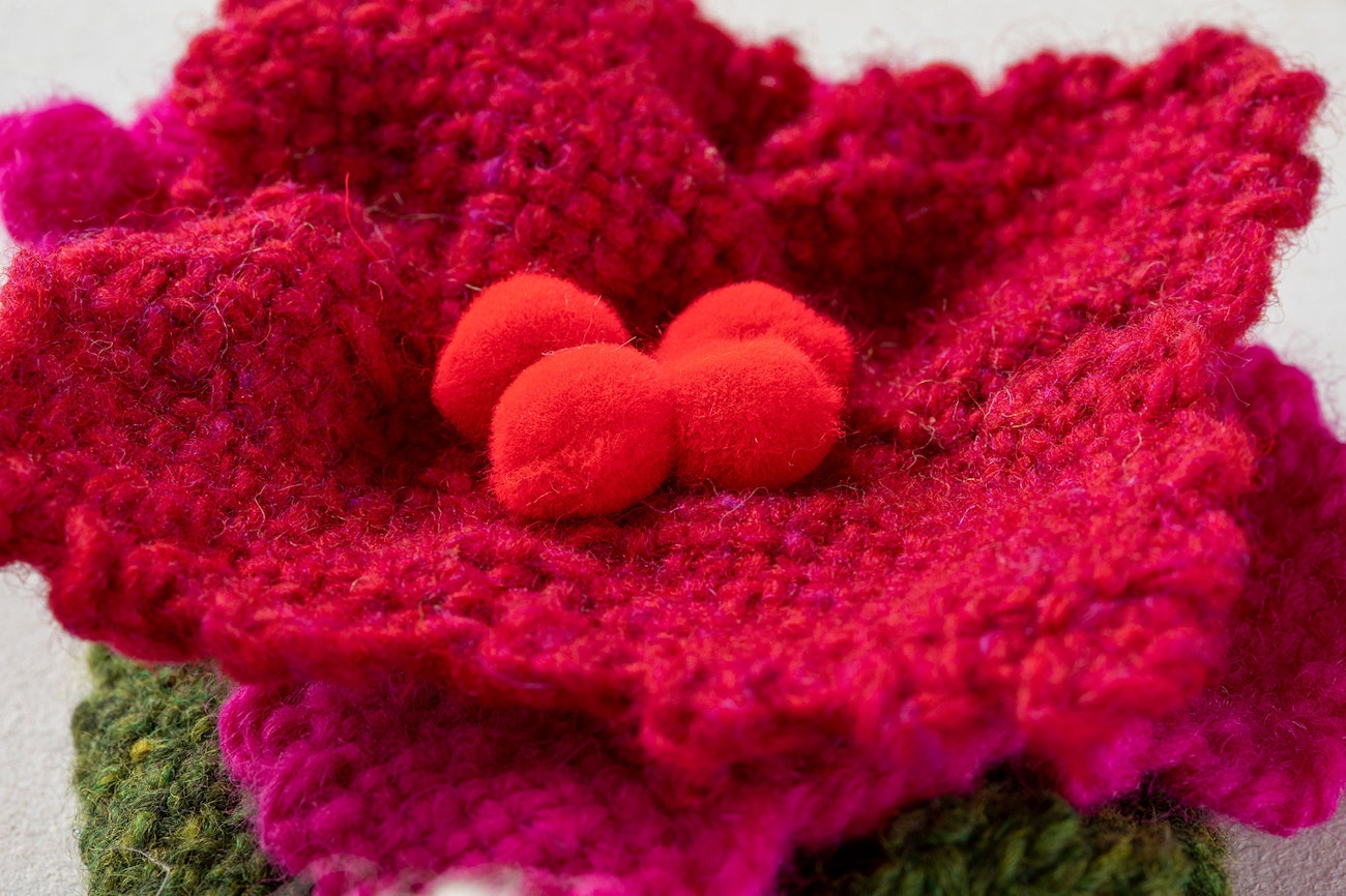 Sew 3 or 4 pom-poms in the middle of the top flower, hiding your stitches.