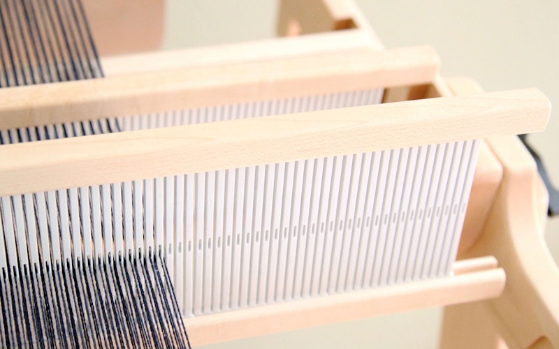 Two heddles are warped on a rigid-heddle loom.